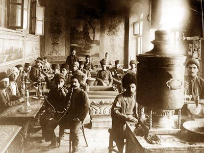 Old sepia photograph of a crowded Baku tea house with a large samovar