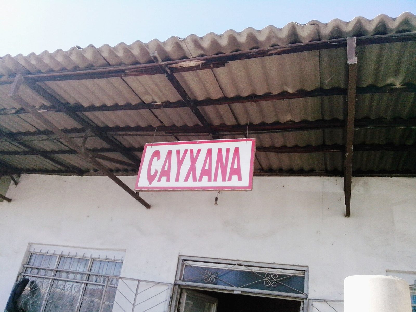 A pink sign reading ÇAYXANA under a corrugated roof in the town of Quba