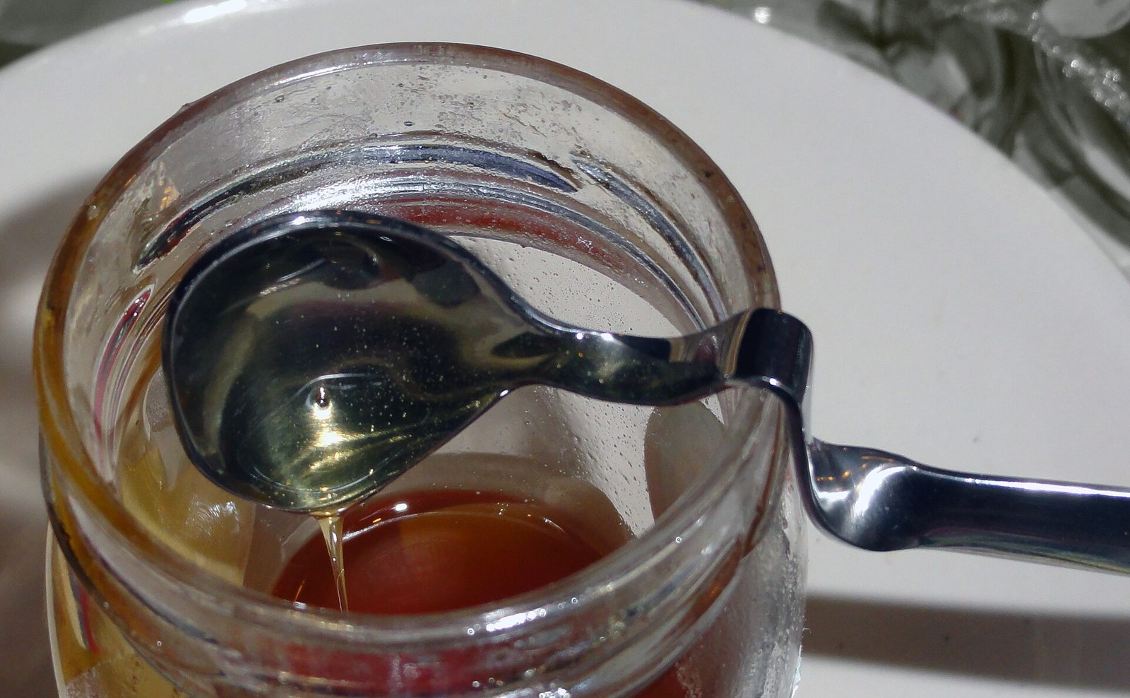 A spoon resting in a jar of honey